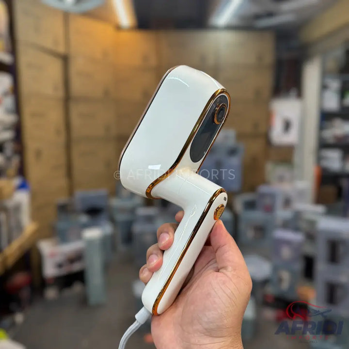 White and gold handheld garment steamer.