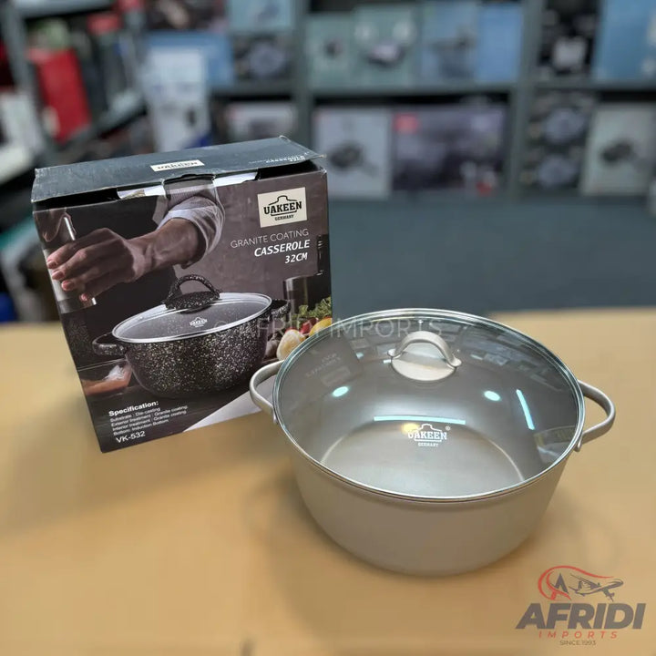 A casserole pot with a glass lid and granite coating, presented in its product box.