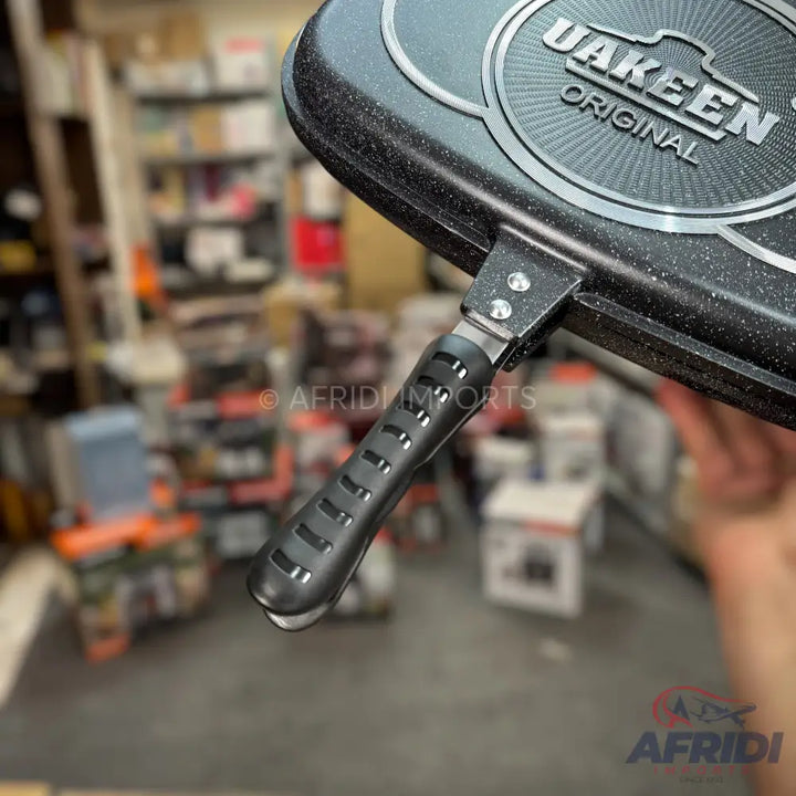 Black speckled double-sided non-stick frying pan with a ribbed handle.