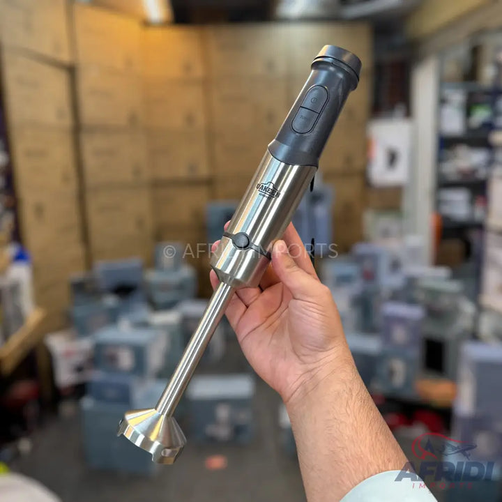 A metallic immersion blender with a dark grey handle and buttons.