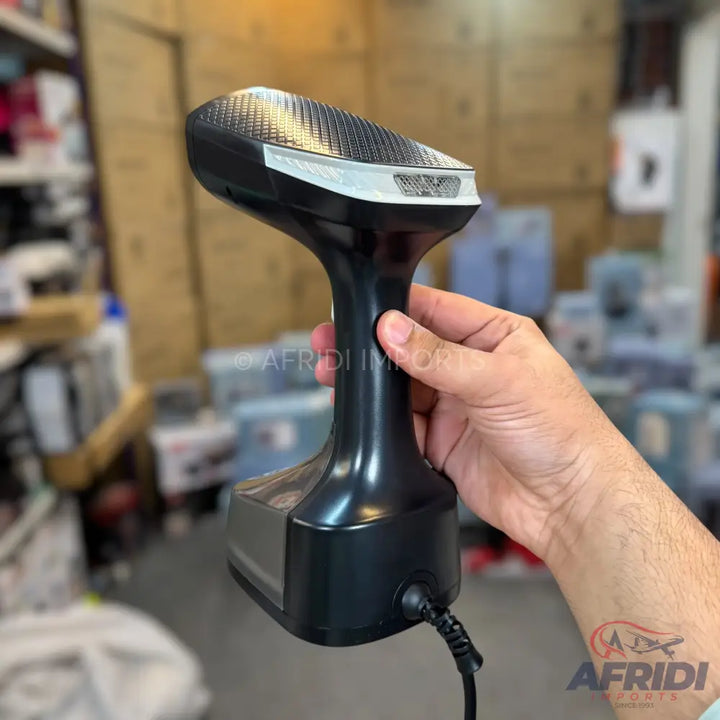 Handheld garment steamer with a dark finish and a textured head.