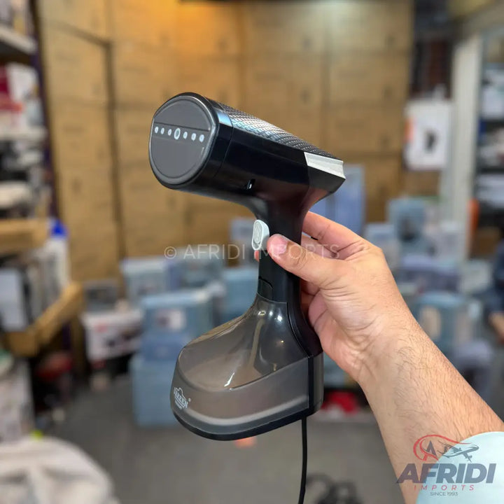 A black handheld garment steamer with a transparent water tank and a gray steaming plate.