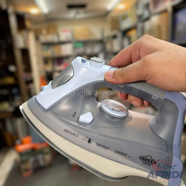 A grey and white steam iron with a non-stick soleplate.