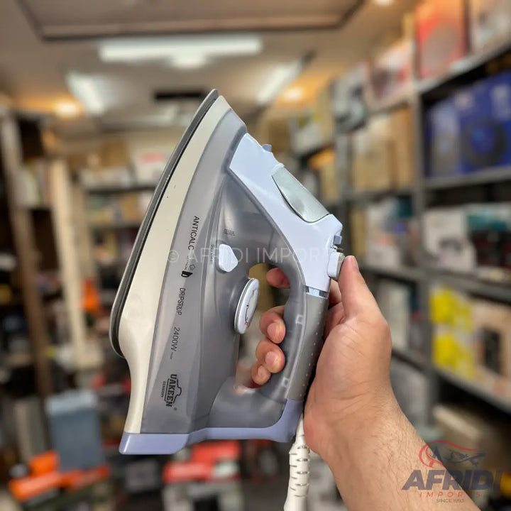 A gray and light blue steam iron with a white power cord.