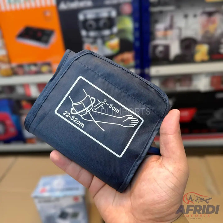 A dark blue blood pressure monitor cuff with an arm placement diagram.