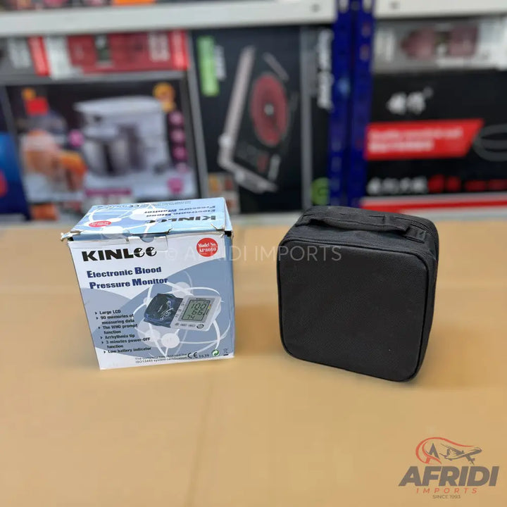 A boxed electronic blood pressure monitor with a separate black carrying case.