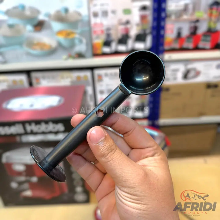 Black plastic coffee scoop with a flat base.