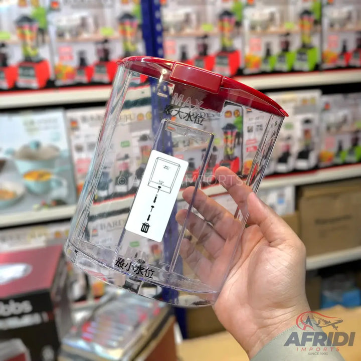 A clear plastic blender jug with a red lid.