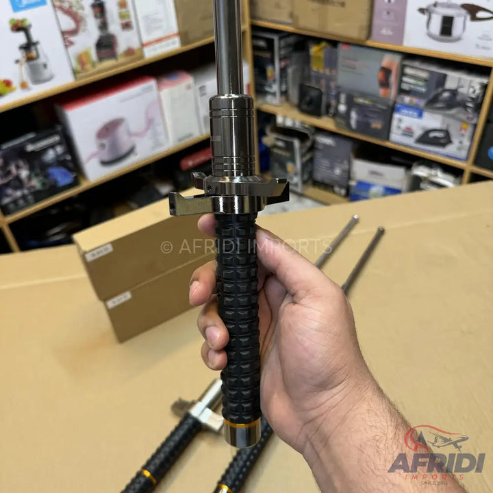 A black-handled metal extendable baton.