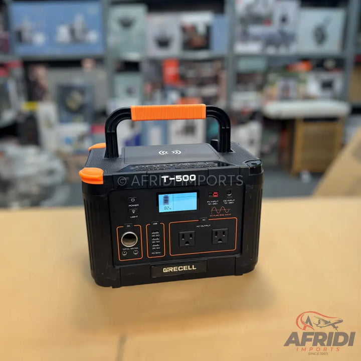 Portable black power station with orange accents and multiple power outlets.