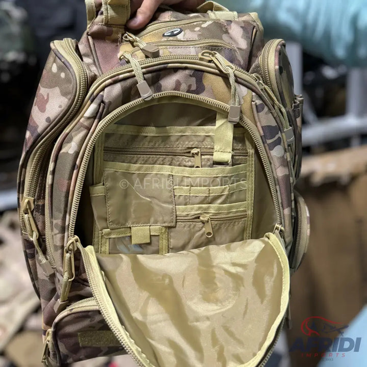 Open camouflage tactical backpack with multiple compartments and a tan interior.