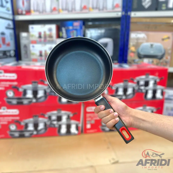 Black non-stick frying pan with a black and red handle.