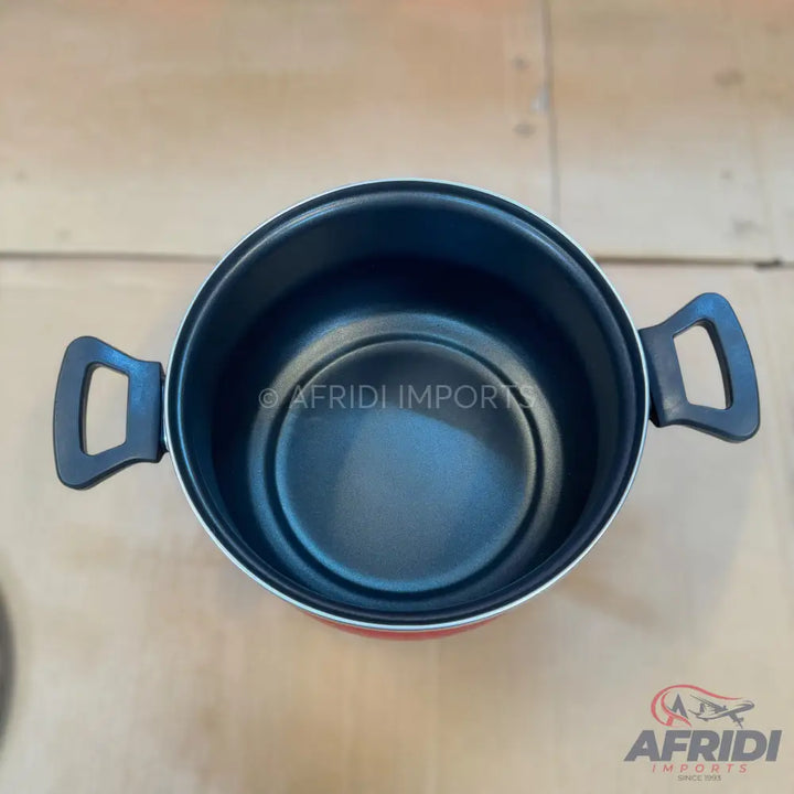 Red cooking pot with black interior and handles.