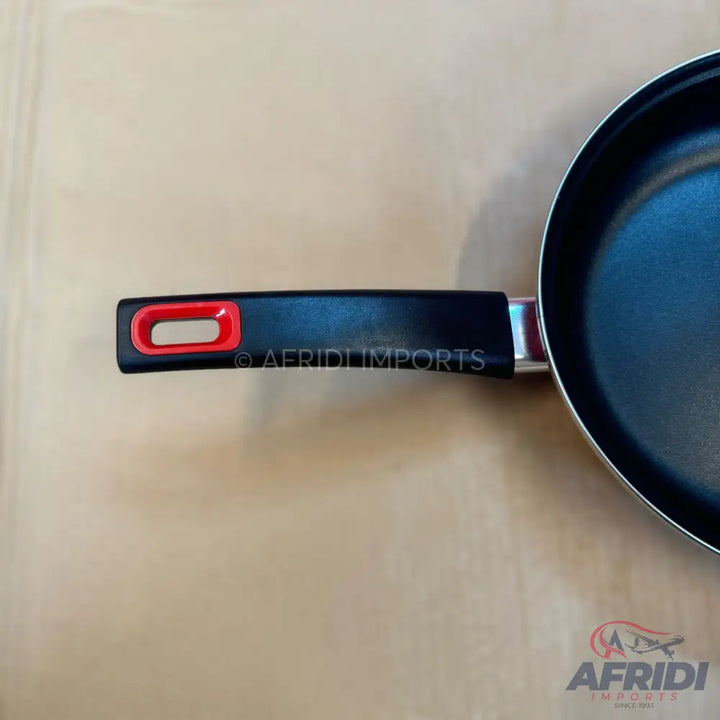 Black non-stick frying pan with a black handle and a red accent.