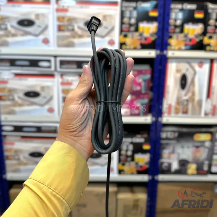 A coiled black power cable with an L-shaped two-prong plug.