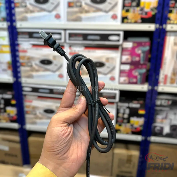 Hand holding a coiled black electrical power cord with a two-prong plug.