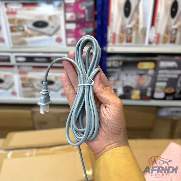 A hand holding a coiled gray electrical cord with a two-pronged plug.