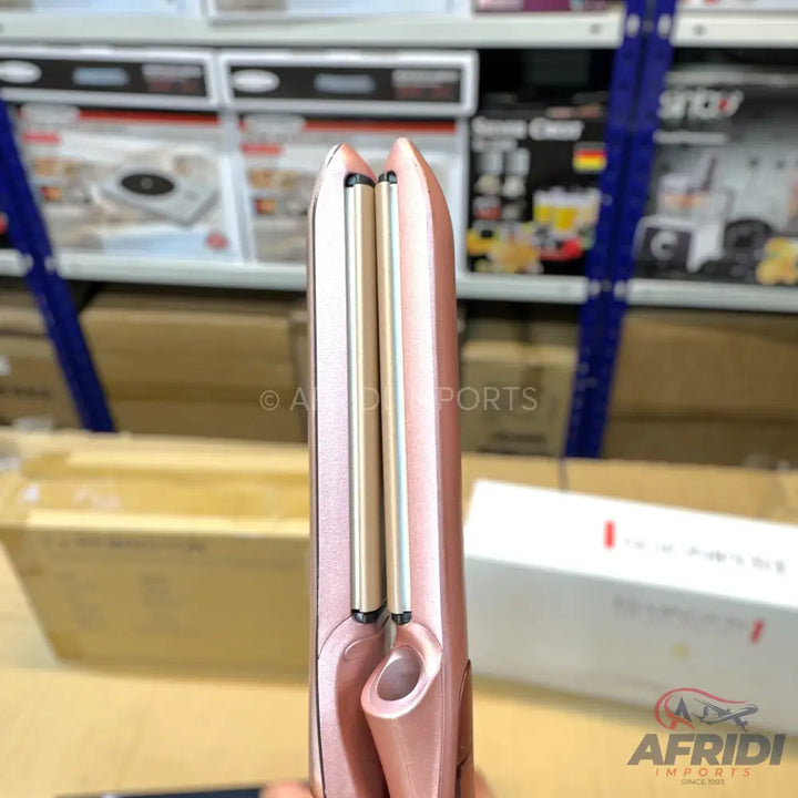 Rose gold hair curler with dual heating rods.