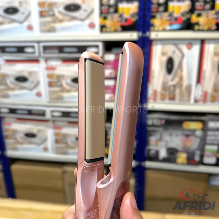 A rose gold hair straightener with ceramic plates.