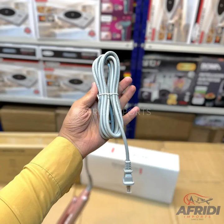 A hand holding a coiled gray electrical cord with a two-prong plug.