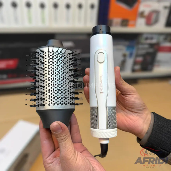 A white hot air styling brush with a detachable round brush head.
