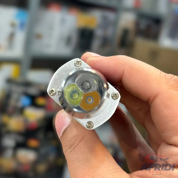 A small, silver-colored, multi-LED flashlight with three distinct colored emitters (white, green, and amber).