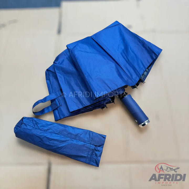 A blue collapsible umbrella with its matching storage sleeve.