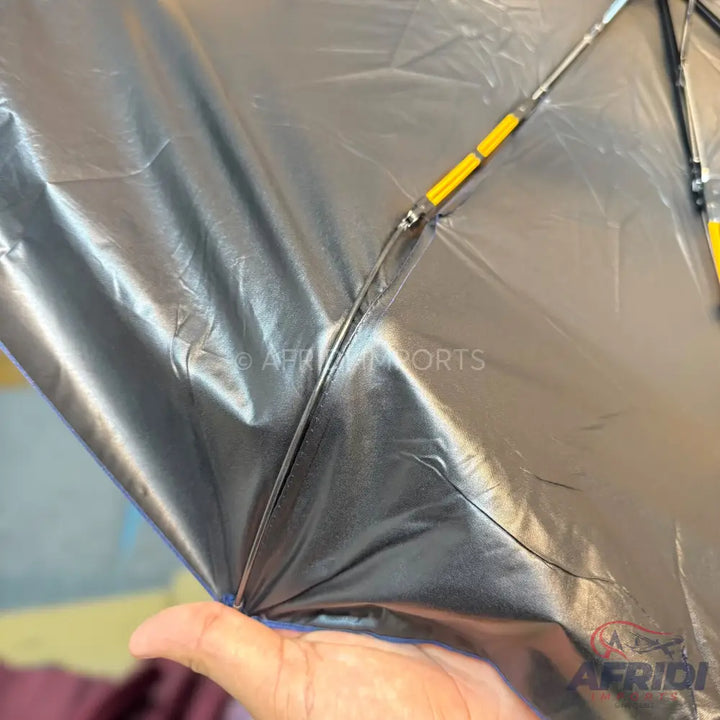 A black, shiny, wrinkle-resistant kite with a yellow and silver frame.