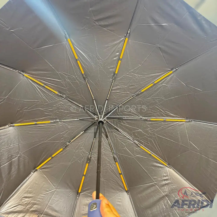 An open umbrella with a silver interior and yellow accents on the ribs.