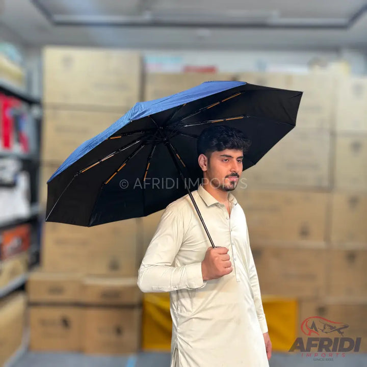 Dark blue and black umbrella with a light-colored handle.