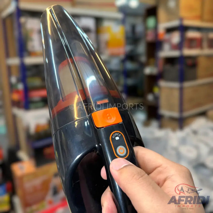 Black handheld cordless vacuum cleaner with an orange power button.