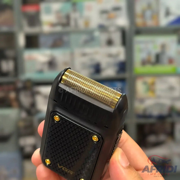 Black electric shaver with a gold-colored foil head.
