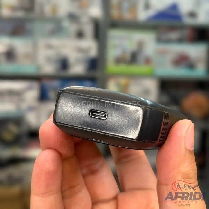 A black, compact electronic device with a USB-C charging port.
