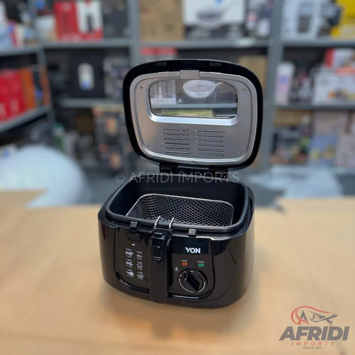Black deep fryer with an open lid and a wire basket inside.