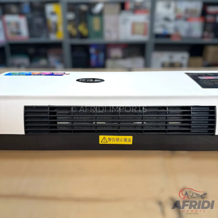 White flat panel heater with a black grille and a yellow warning label.