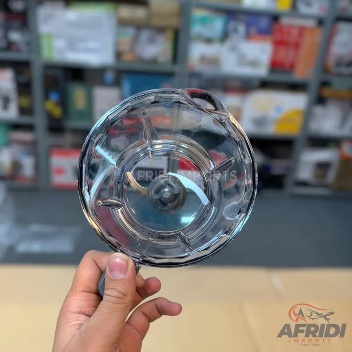 A hand-held, clear plastic vegetable chopper with a two-blade insert.