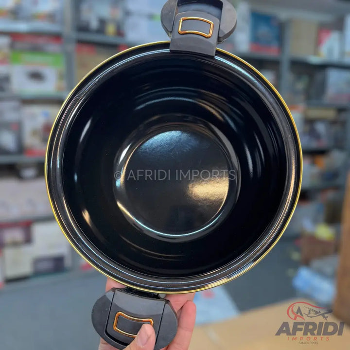 Black non-stick cooking pot with gold trim and foldable handles.