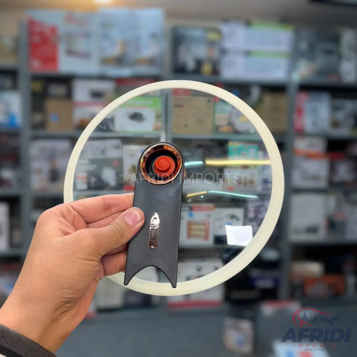Glass lid with a black and rose gold handle and red button.