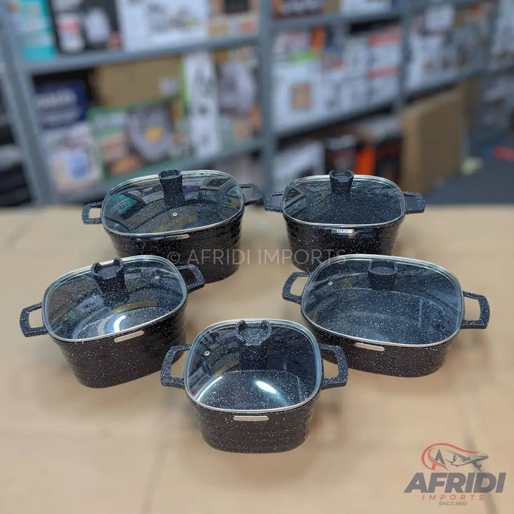 A set of five black speckled non-stick cooking pots with glass lids and handles.