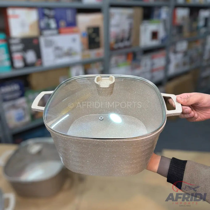 Beige, speckled, rectangular casserole dish with a clear glass lid and two handles.