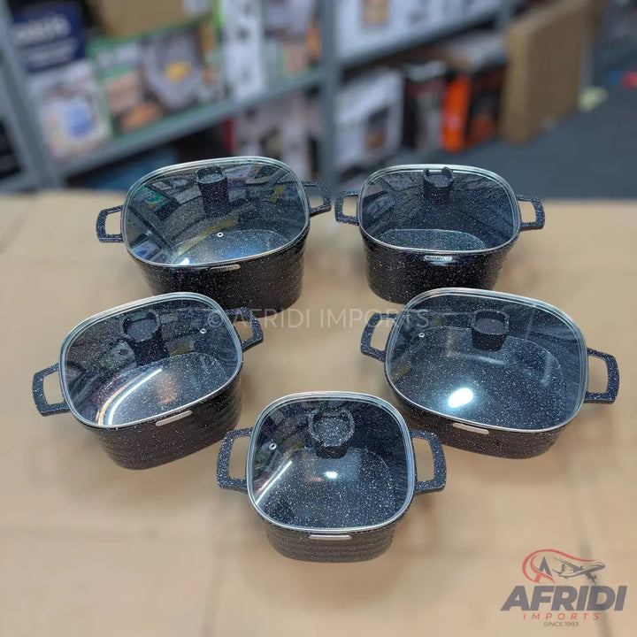 A set of five black speckled non-stick cooking pots with glass lids and integrated handles.