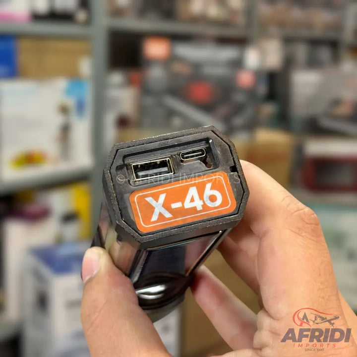 A black power bank with a USB-A and USB-C port, featuring an orange label with ’X-46’’ printed on it.