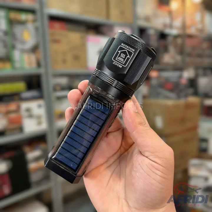 Black solar-powered LED flashlight with zoom and rotation features.