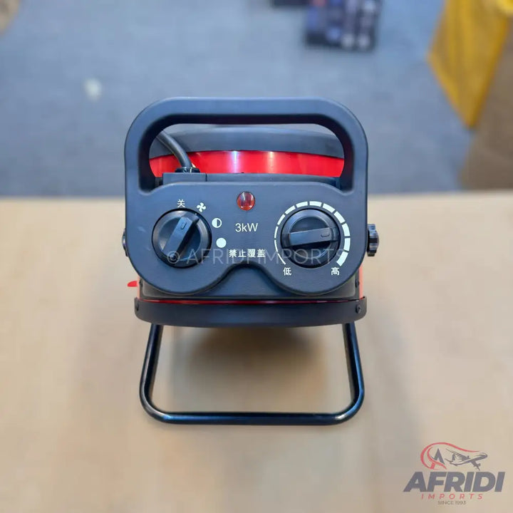 A portable red and black electric heater with a handle and two control knobs.