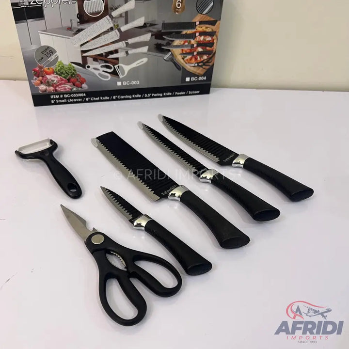 A set of kitchen knives, a peeler, and scissors with black handles.