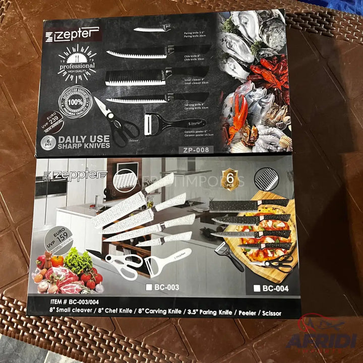 Two boxed sets of kitchen knives, one with black handles and the other with white handles, including various knife types, a peeler, and scissors.