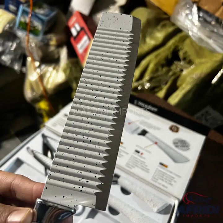 A serrated knife with a speckled, light-colored blade and a metal handle.