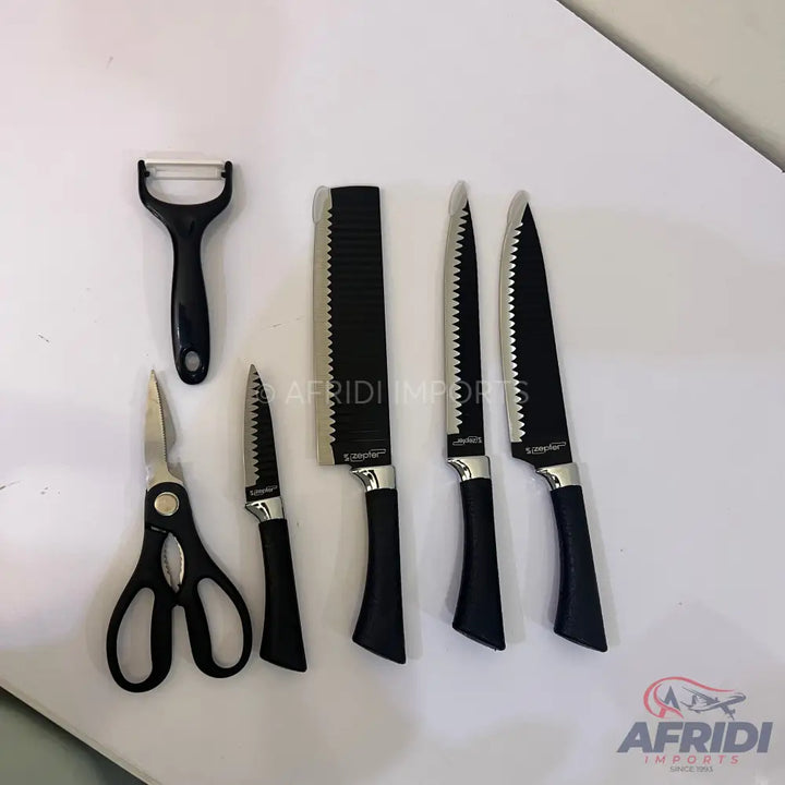 A set of black-handled kitchen knives, a peeler, and scissors.