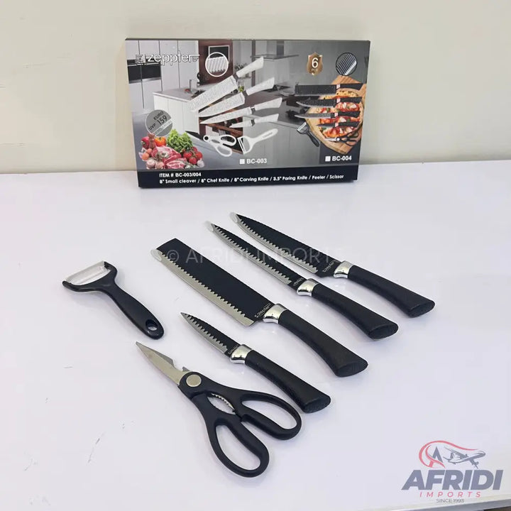 A set of black-handled kitchen knives, a peeler, and scissors.