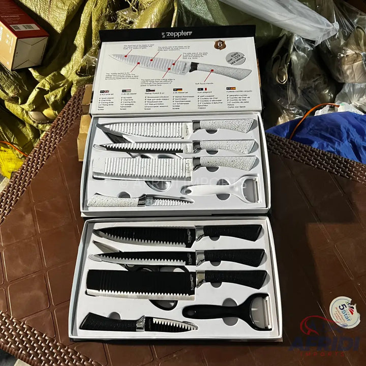 Two knife sets, one with white speckled handles and one with black handles, each containing multiple knives and a peeler.